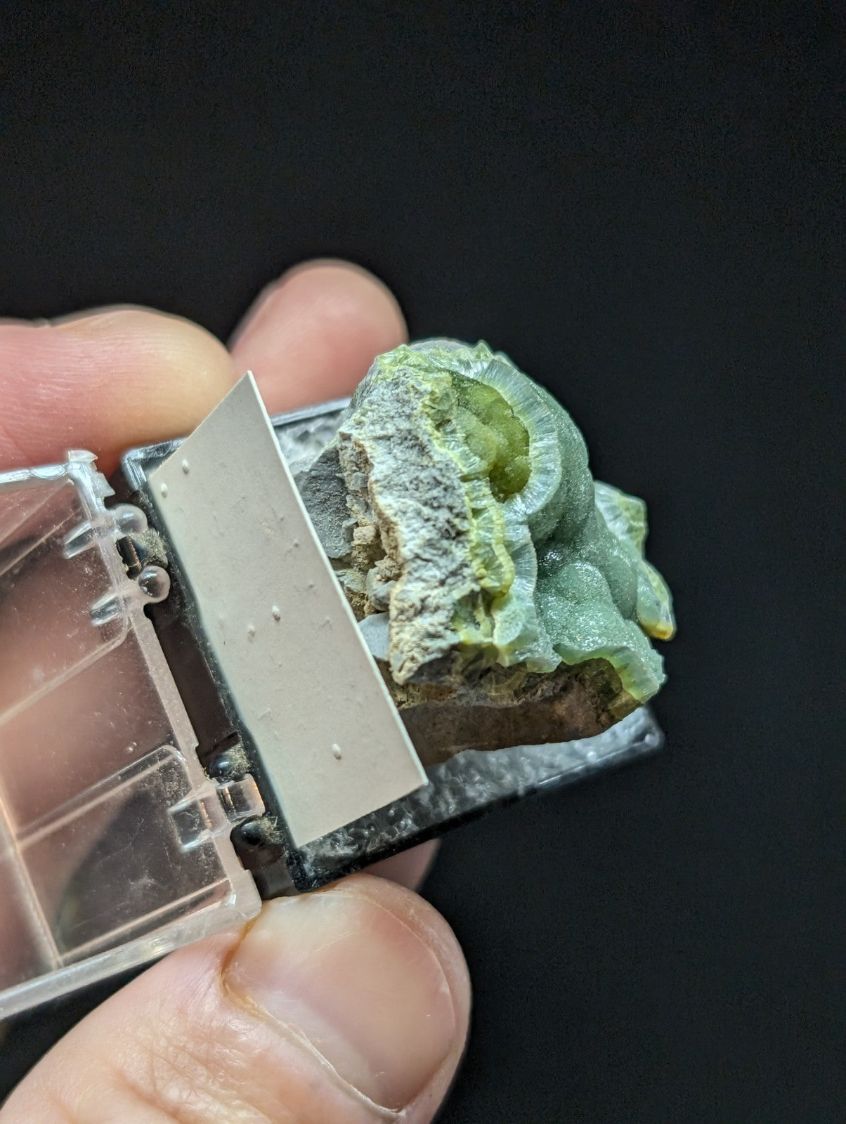 A translucent green and white mineral specimen with a rough, crystalline texture.
