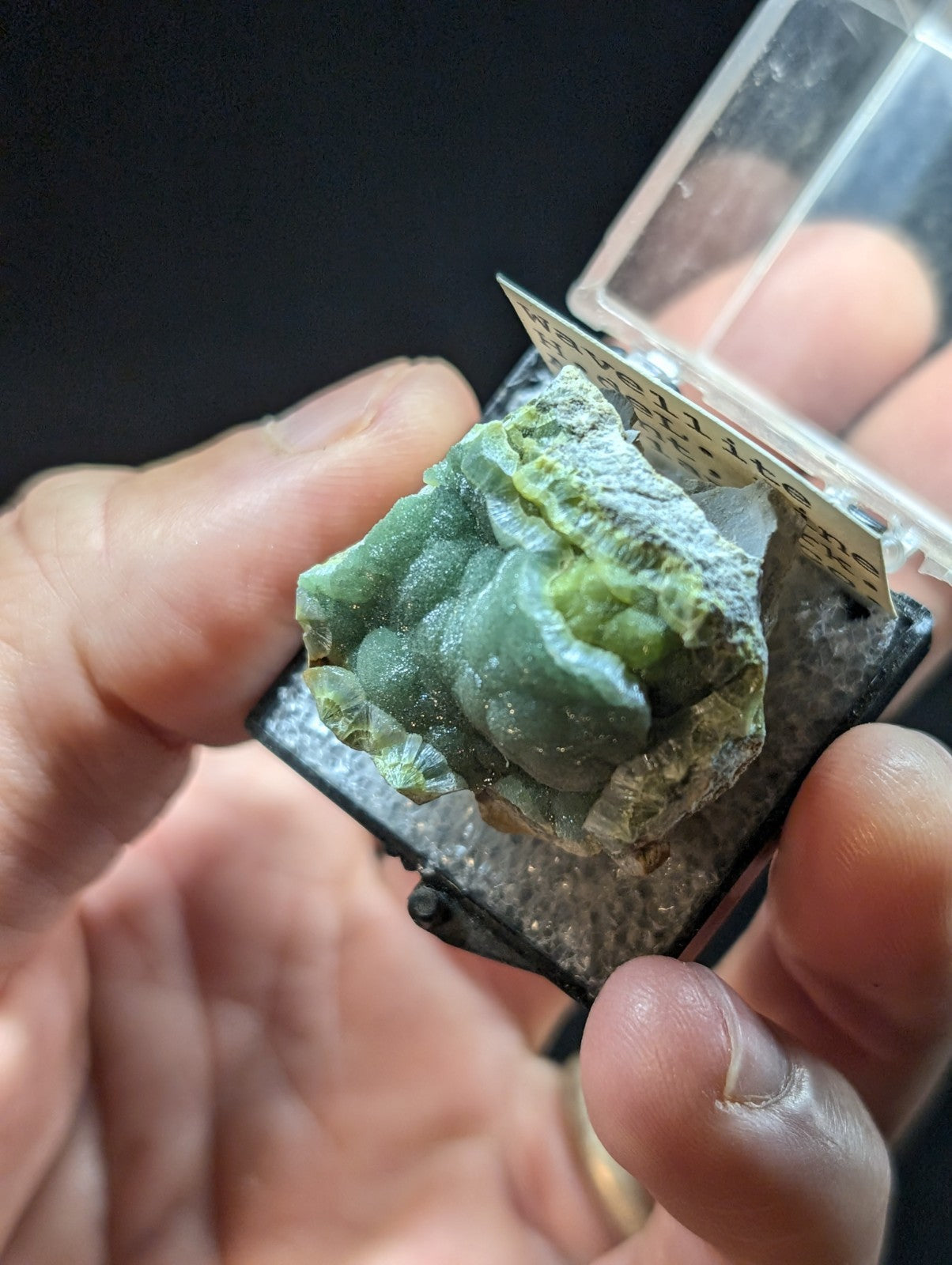 A green, translucent mineral specimen with a rough, crystalline surface and white veining.