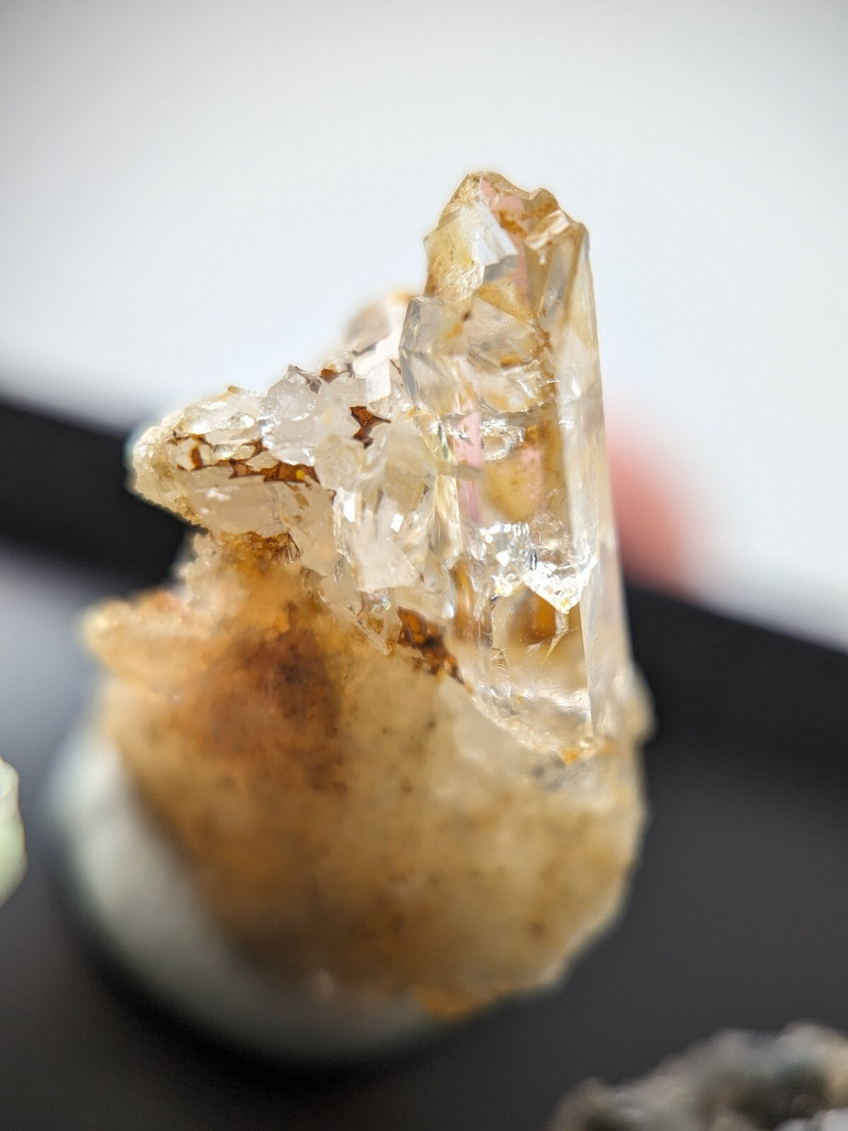 A translucent, amber-hued crystal formation with sharp facets and a rougher base.