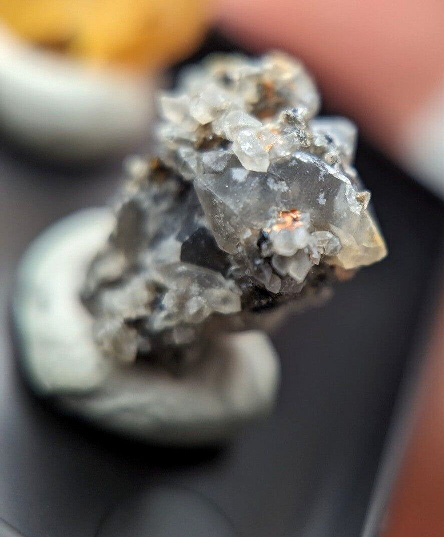 A translucent gray crystal cluster with sharp, faceted points and subtle golden inclusions.