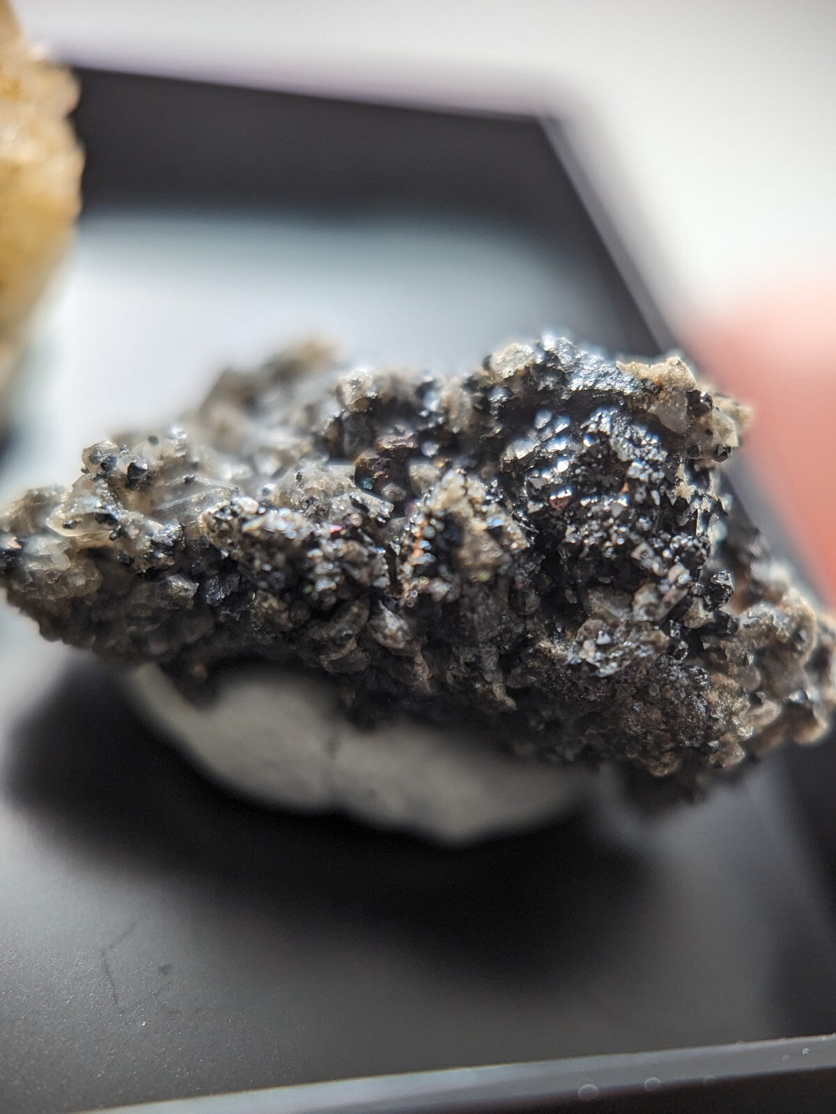 A rugged, dark gray mineral specimen with a rough, crystalline texture and speckled surface.