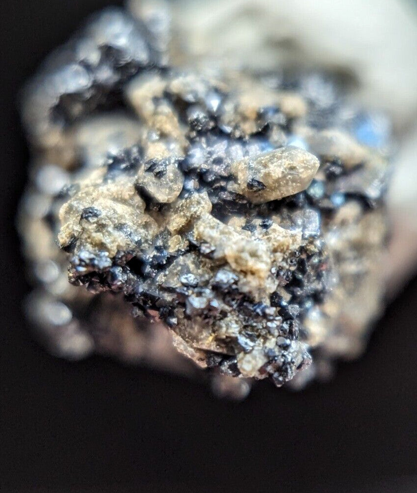 A rugged, irregularly shaped mineral specimen with a textured surface featuring dark black and light tan patches.