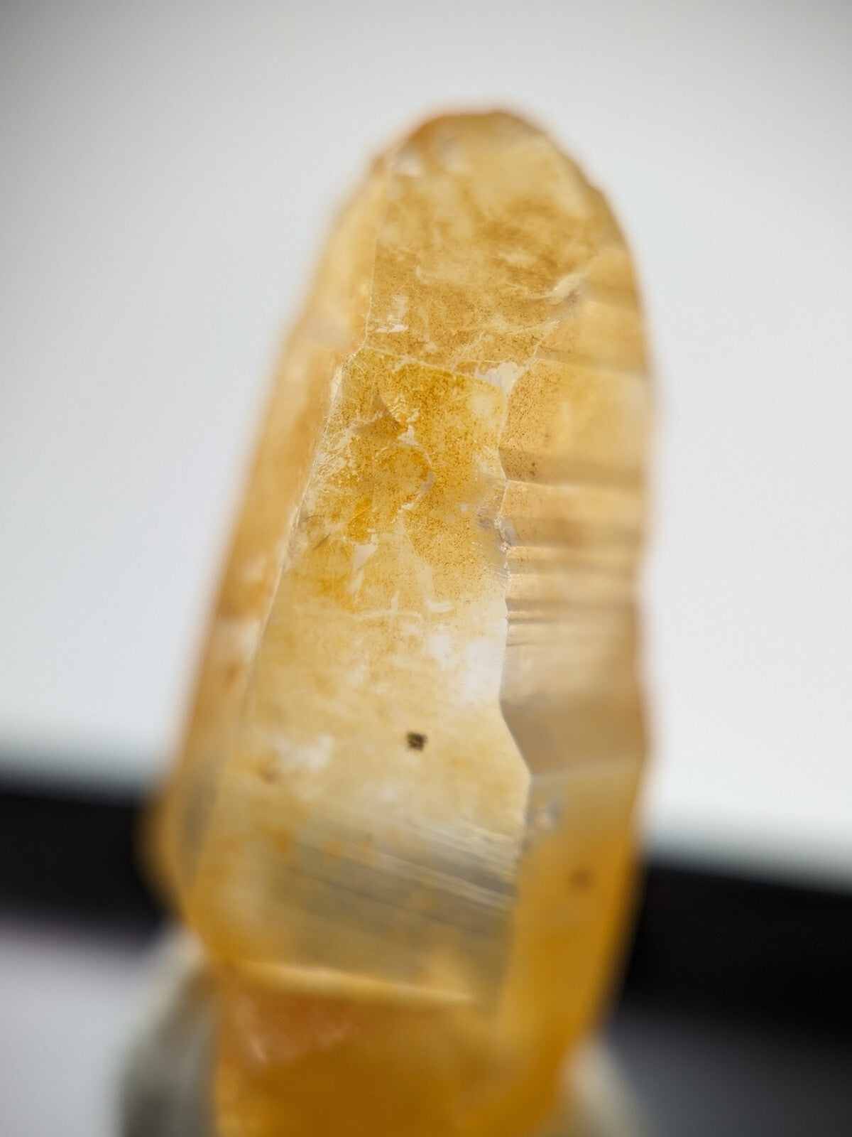 A translucent golden-yellow crystal with natural striations and subtle internal inclusions.