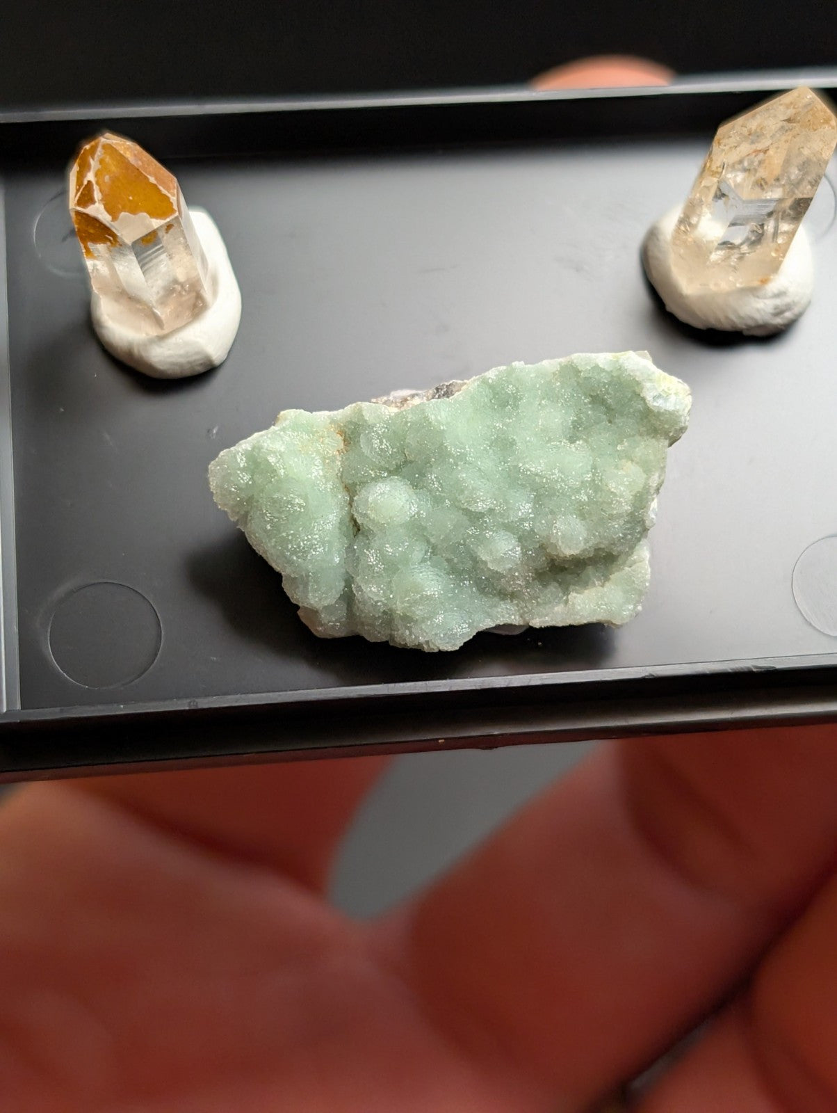A pale green, textured mineral specimen with a crystalline surface.