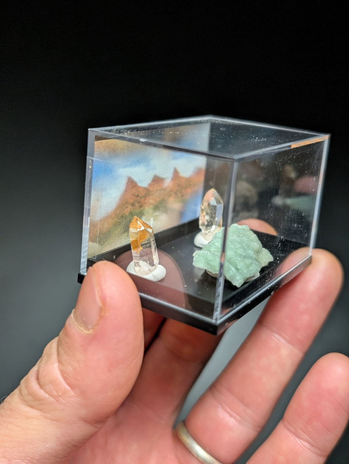 透明立方体展示盒内陈列着几块天然水晶和矿物标本。