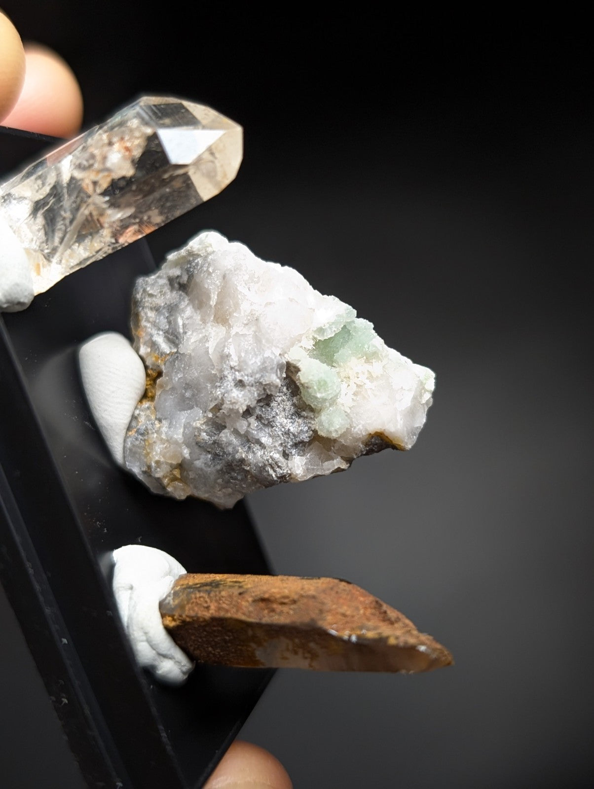 A clear, faceted quartz crystal with a pointed tip and visible internal inclusions.