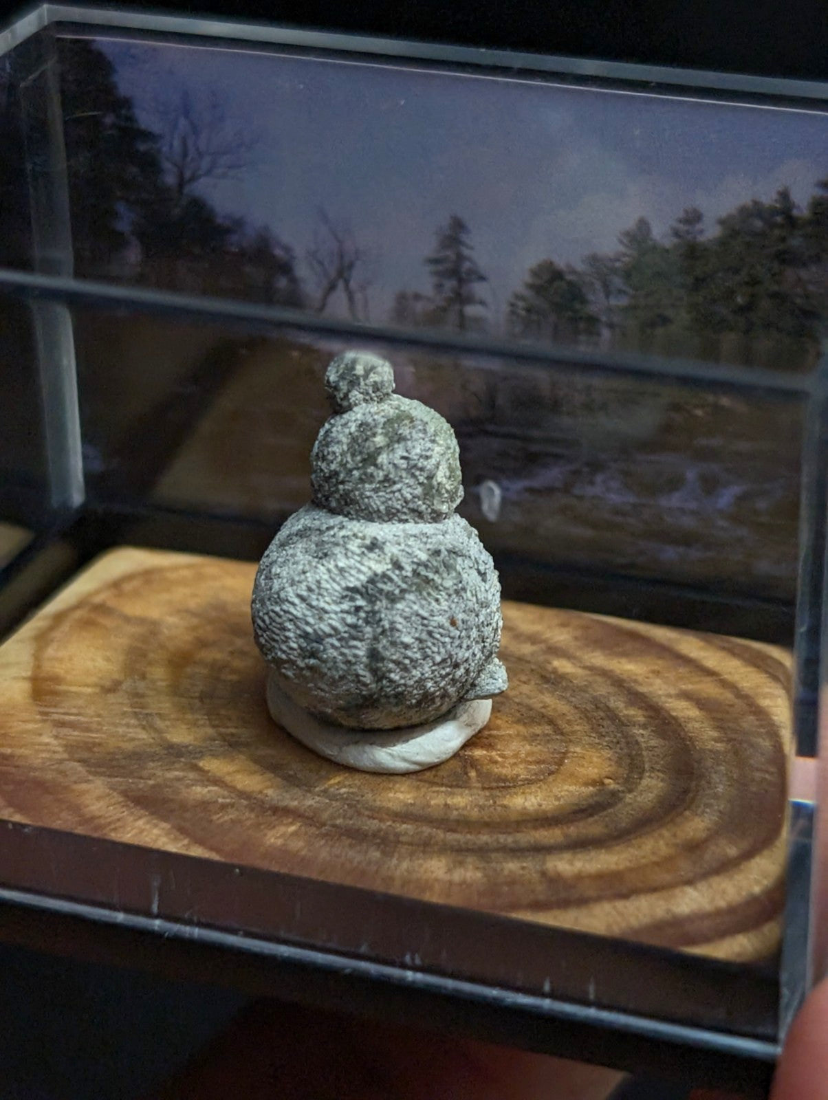 Gray, textured stone figurine shaped like a snowman with two rounded sections and a small ball on top.