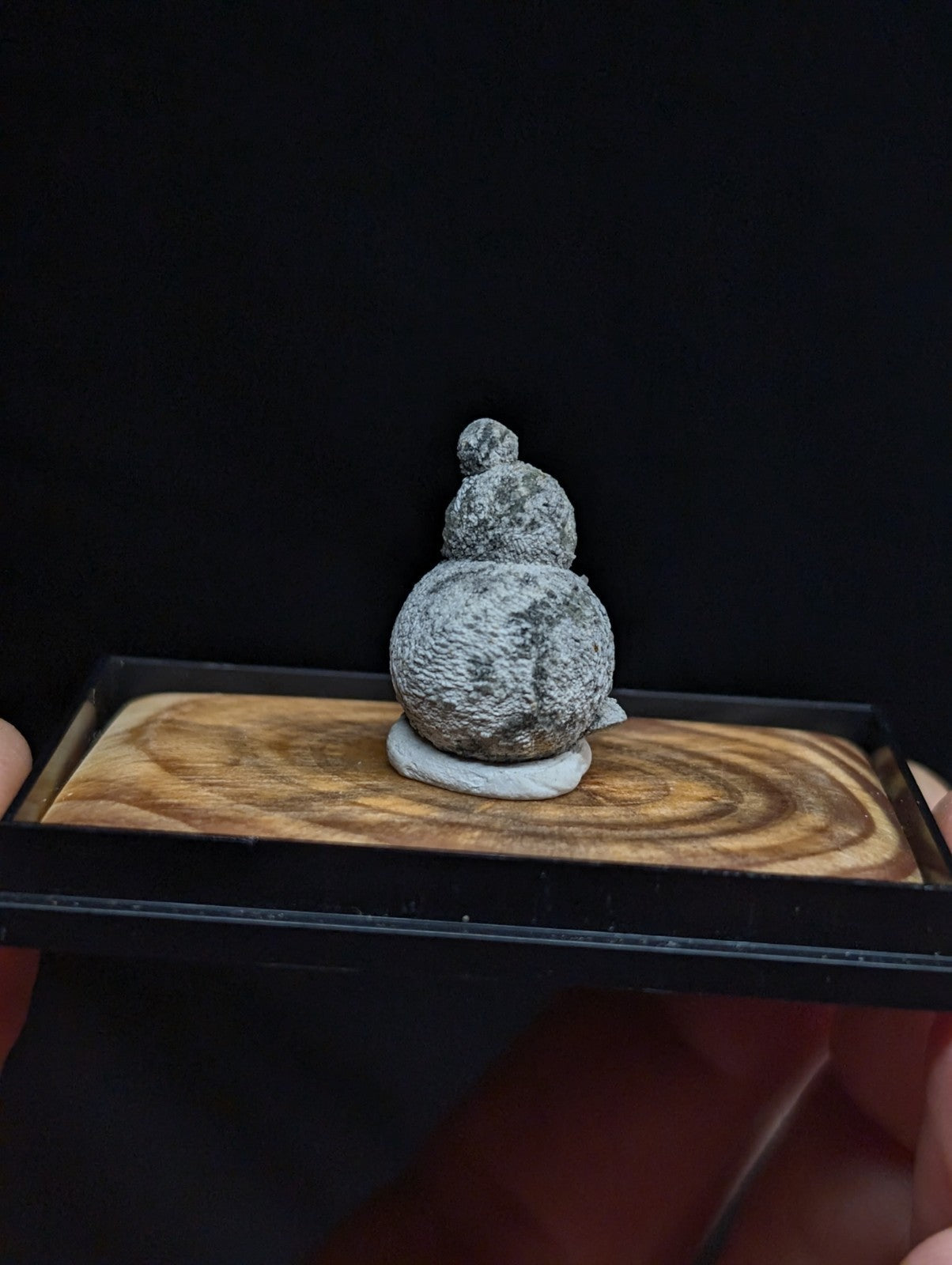 Gray, textured stone gourd figurine with a rounded base and stacked spherical segments.