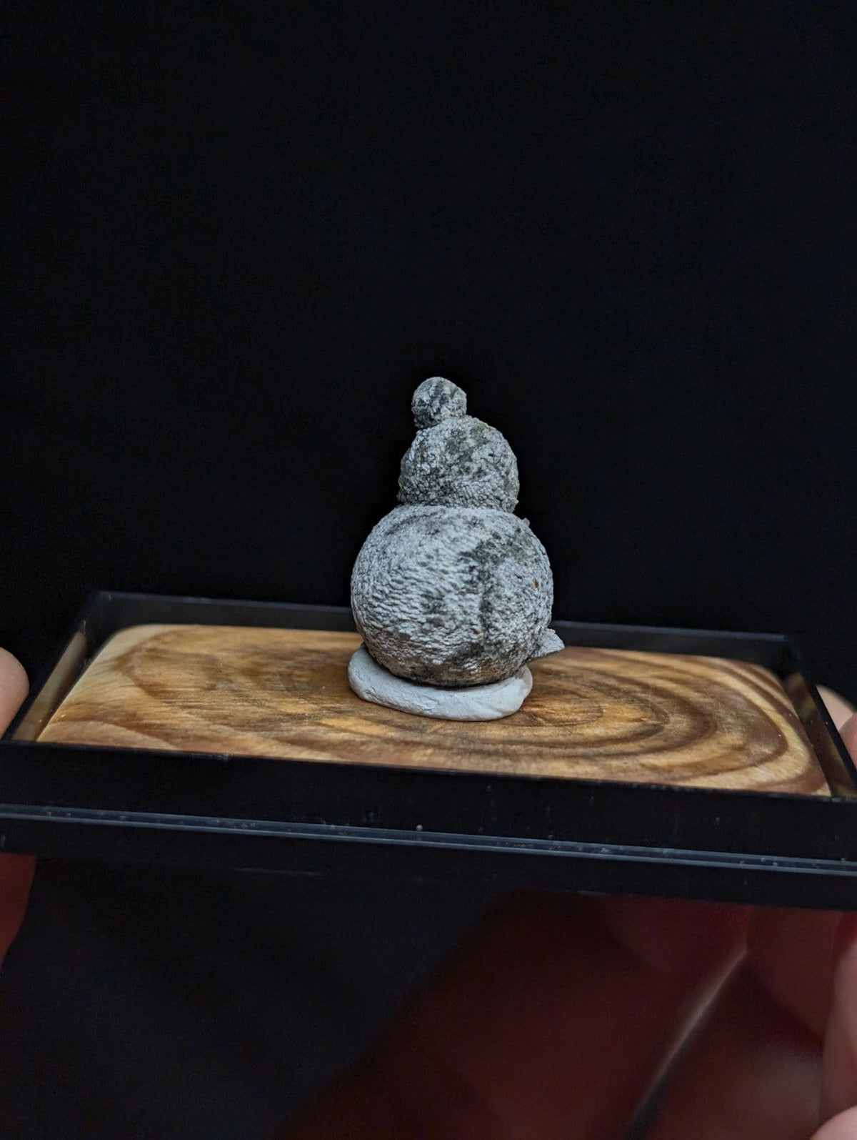 Gray, textured stone gourd figurine with a rounded base and stacked spherical segments.