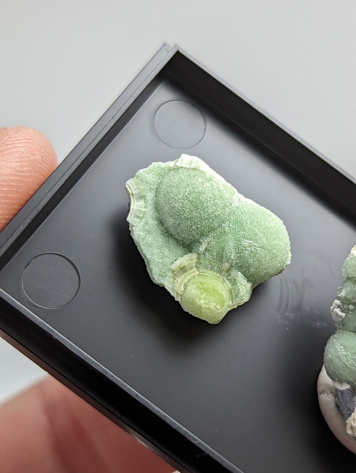 A light green, textured mineral specimen with a rough, irregular surface and subtle color gradient.