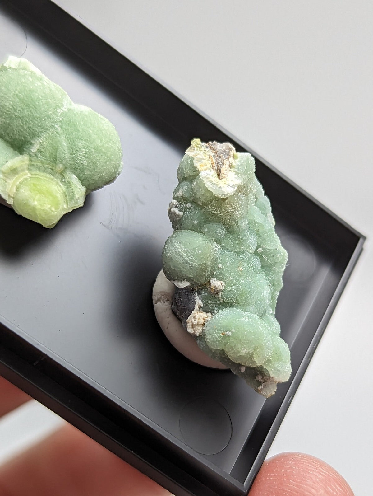 A vibrant green, bubbly mineral specimen with a textured surface and natural imperfections.