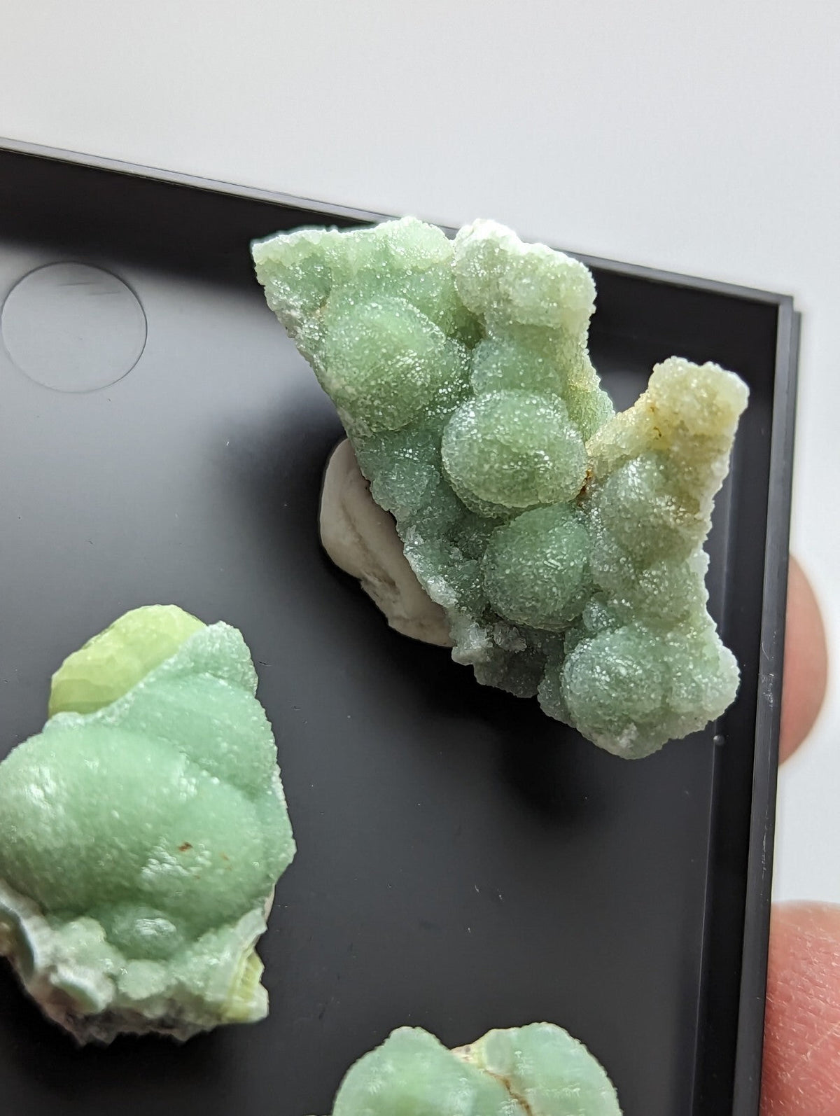 A pale green, bubbly mineral specimen with a crystalline texture and subtle yellowish highlights.