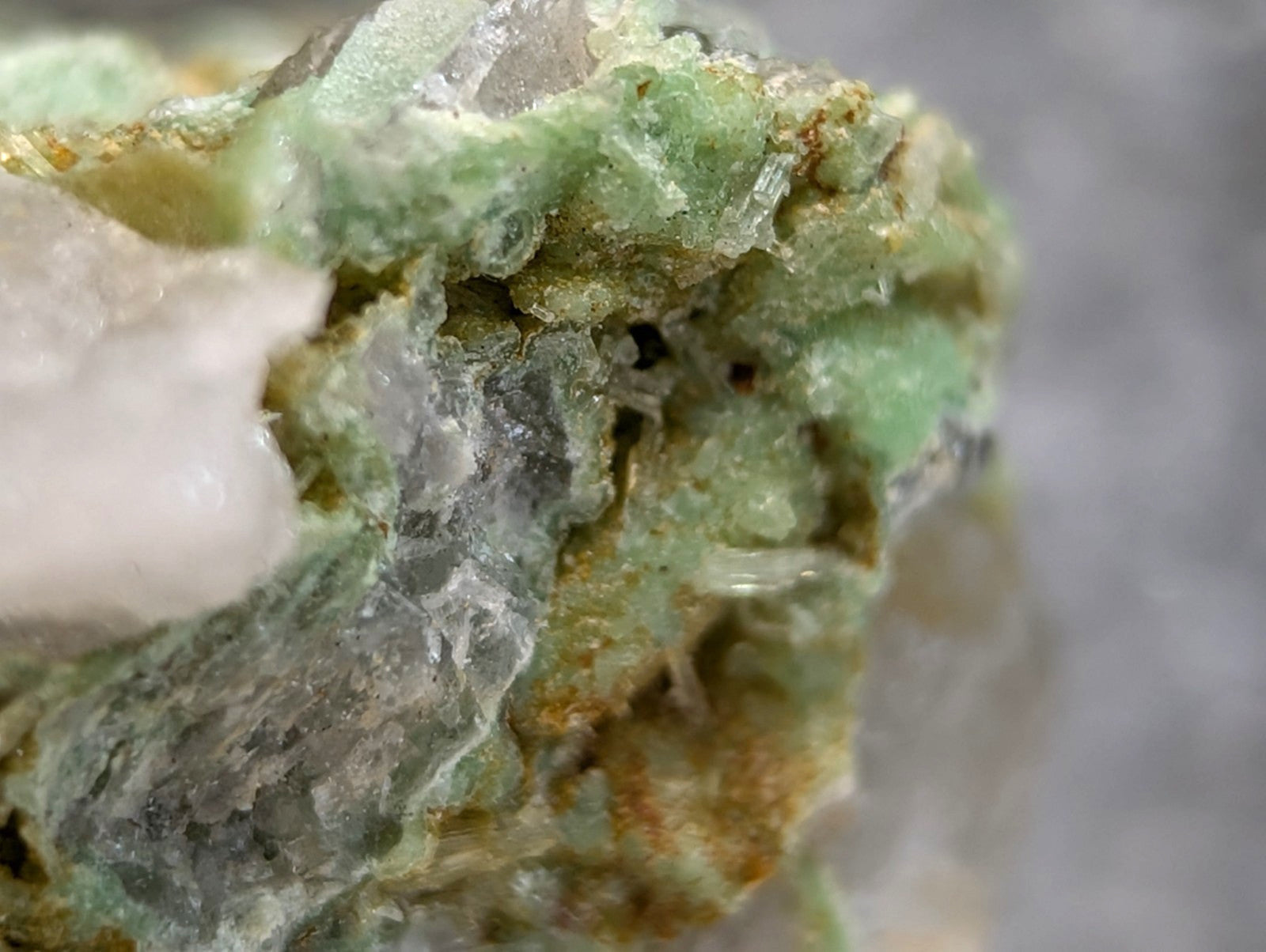 Wavellite on variscite mineral with rough greenish surface translucent crystals and yellow brown patches from Arkansas