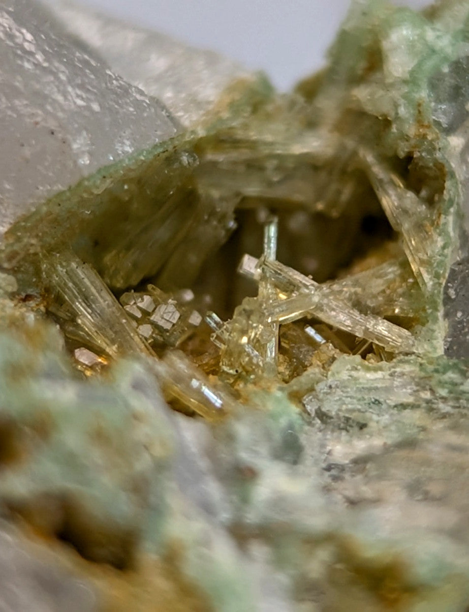 A cluster of translucent golden-yellow wavellite crystals on greenish variscite matrix from Polk County Arkansas