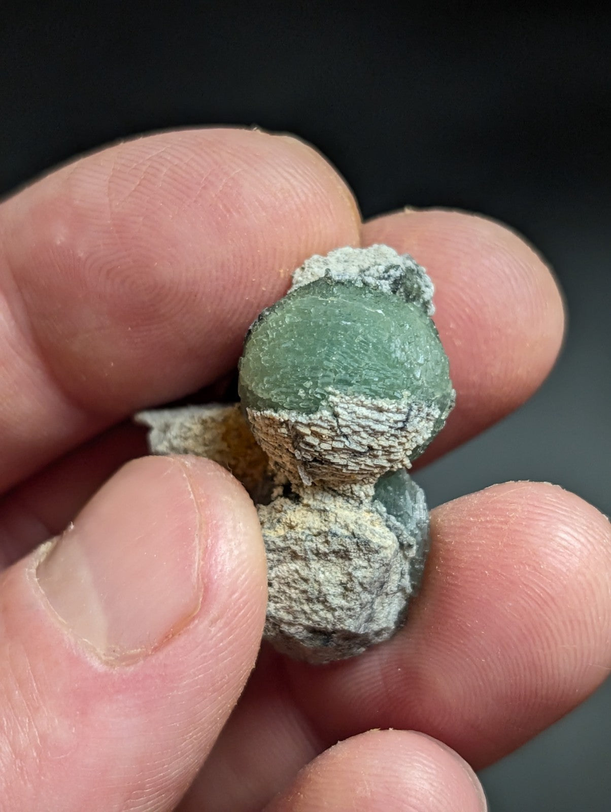 A weathered green jade figurine with a textured, mossy patina and visible cracks.