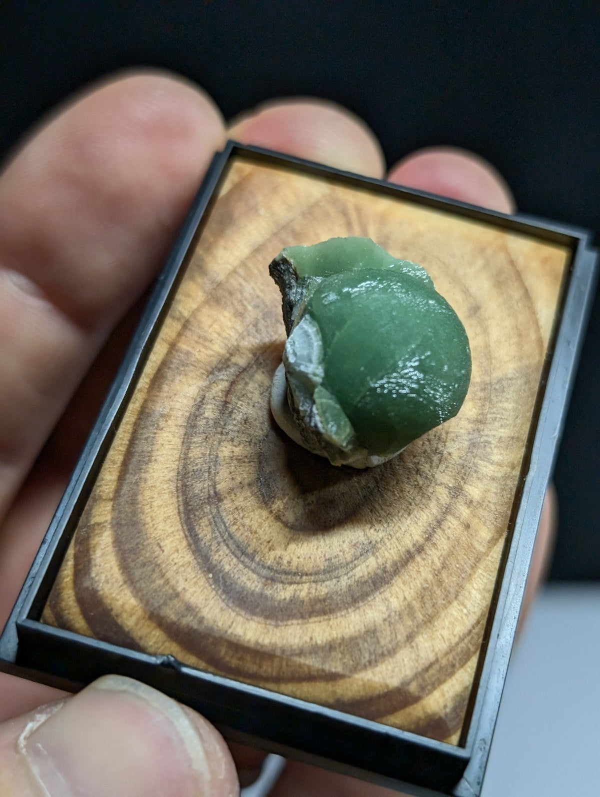 A smooth, translucent green jade stone with a polished surface and natural irregular shape.