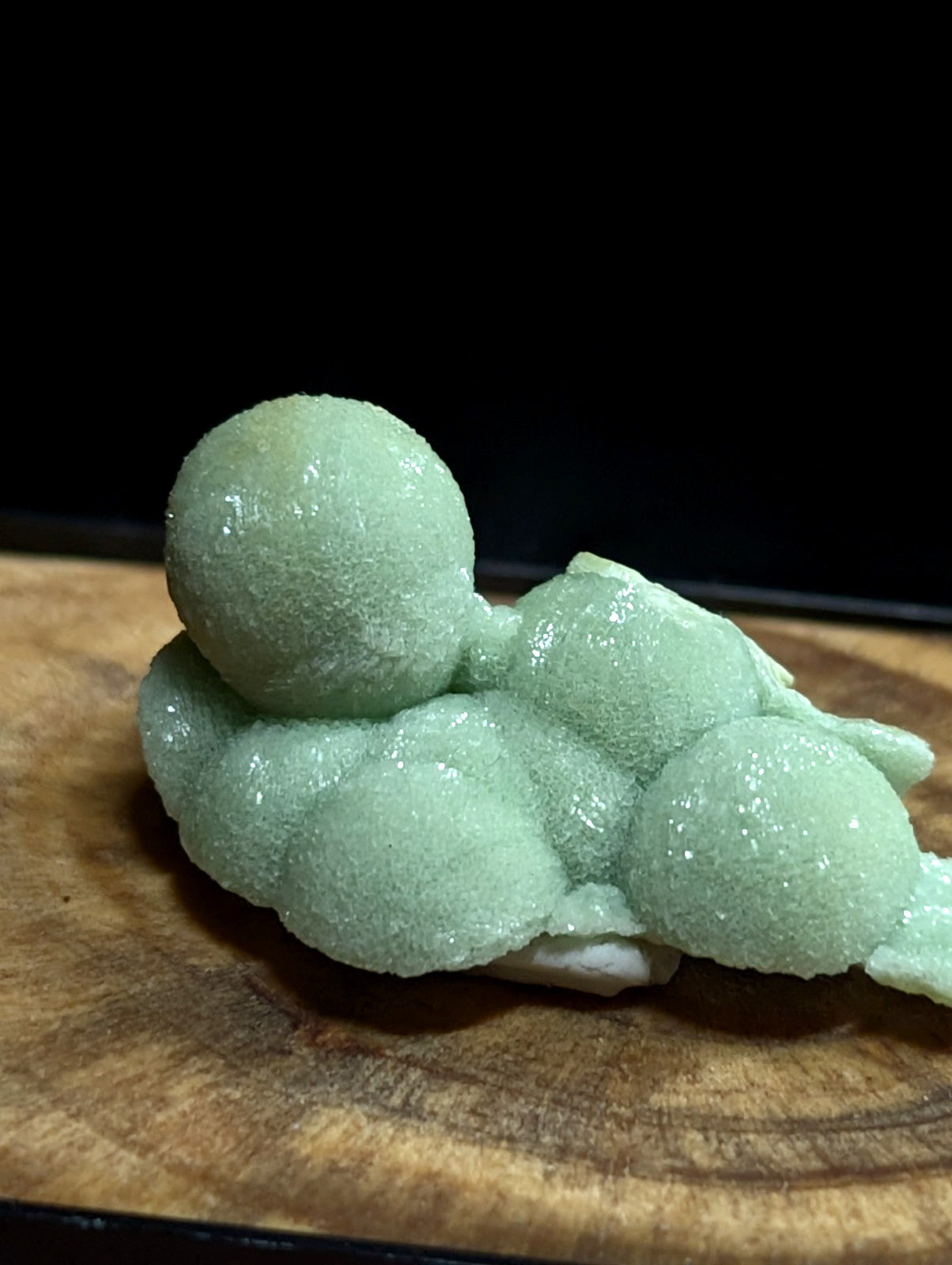 A delicate, light green frosted dessert shaped like a reclining figure with rounded limbs and head.