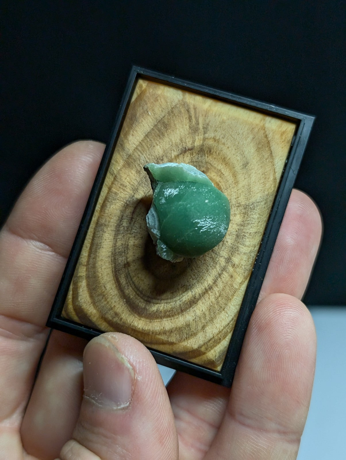 A smooth, translucent green jade stone with a slightly irregular shape and natural surface texture.