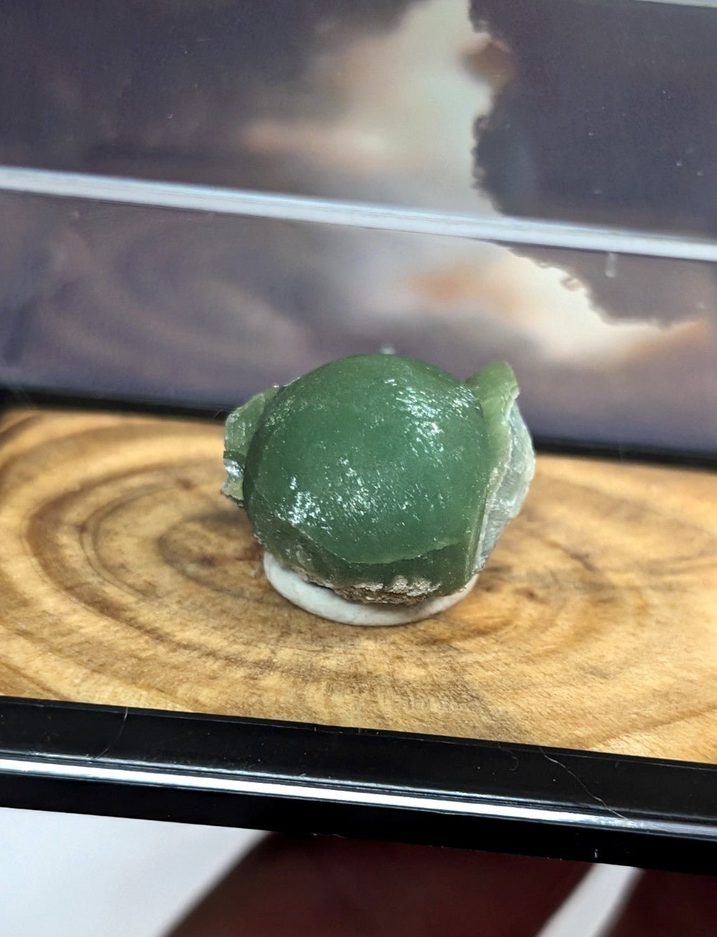 A translucent green jade-like stone with a smooth, rounded surface and subtle natural veining.