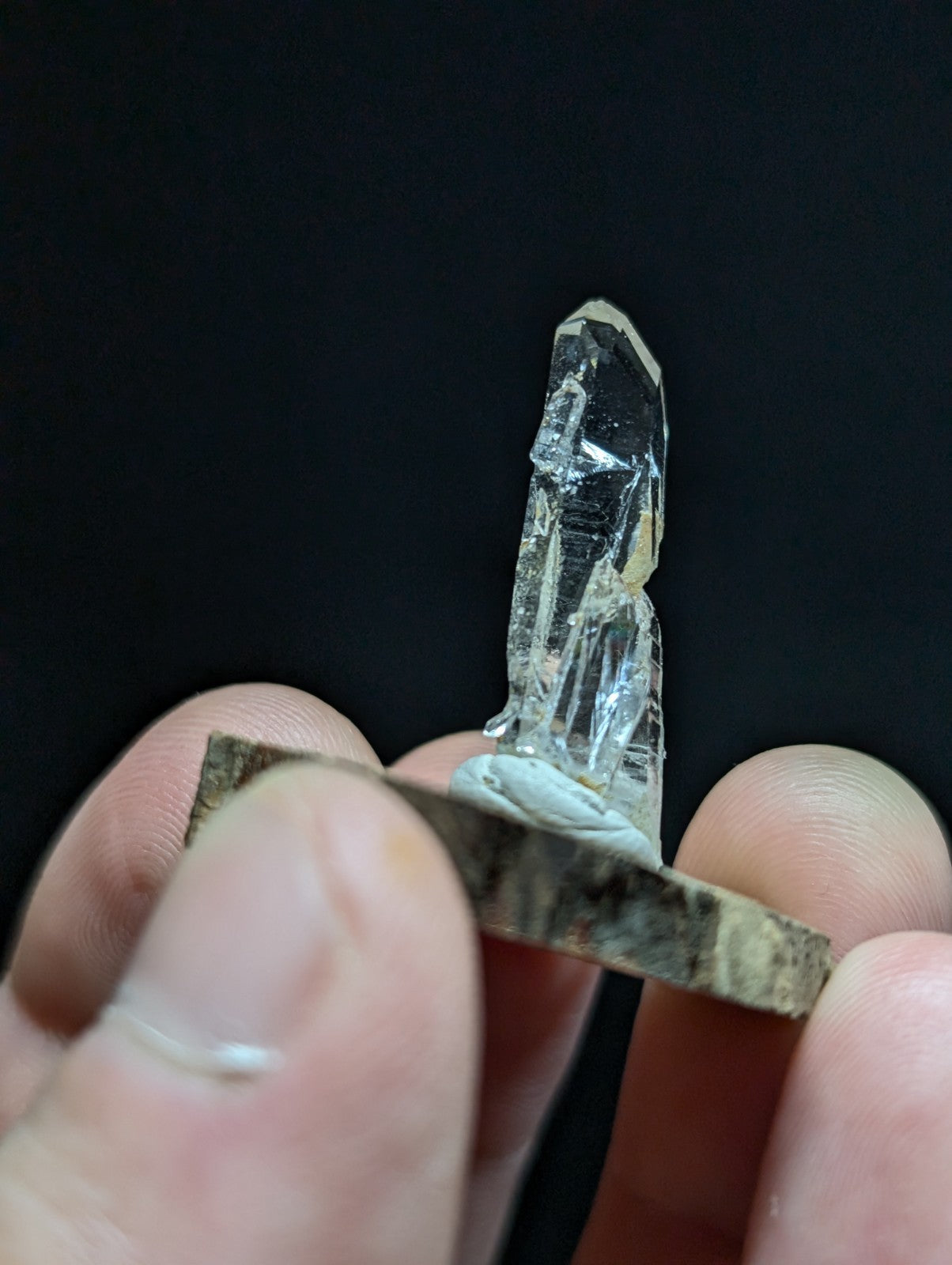 A clear, transparent quartz crystal with a pointed tip and visible internal facets.