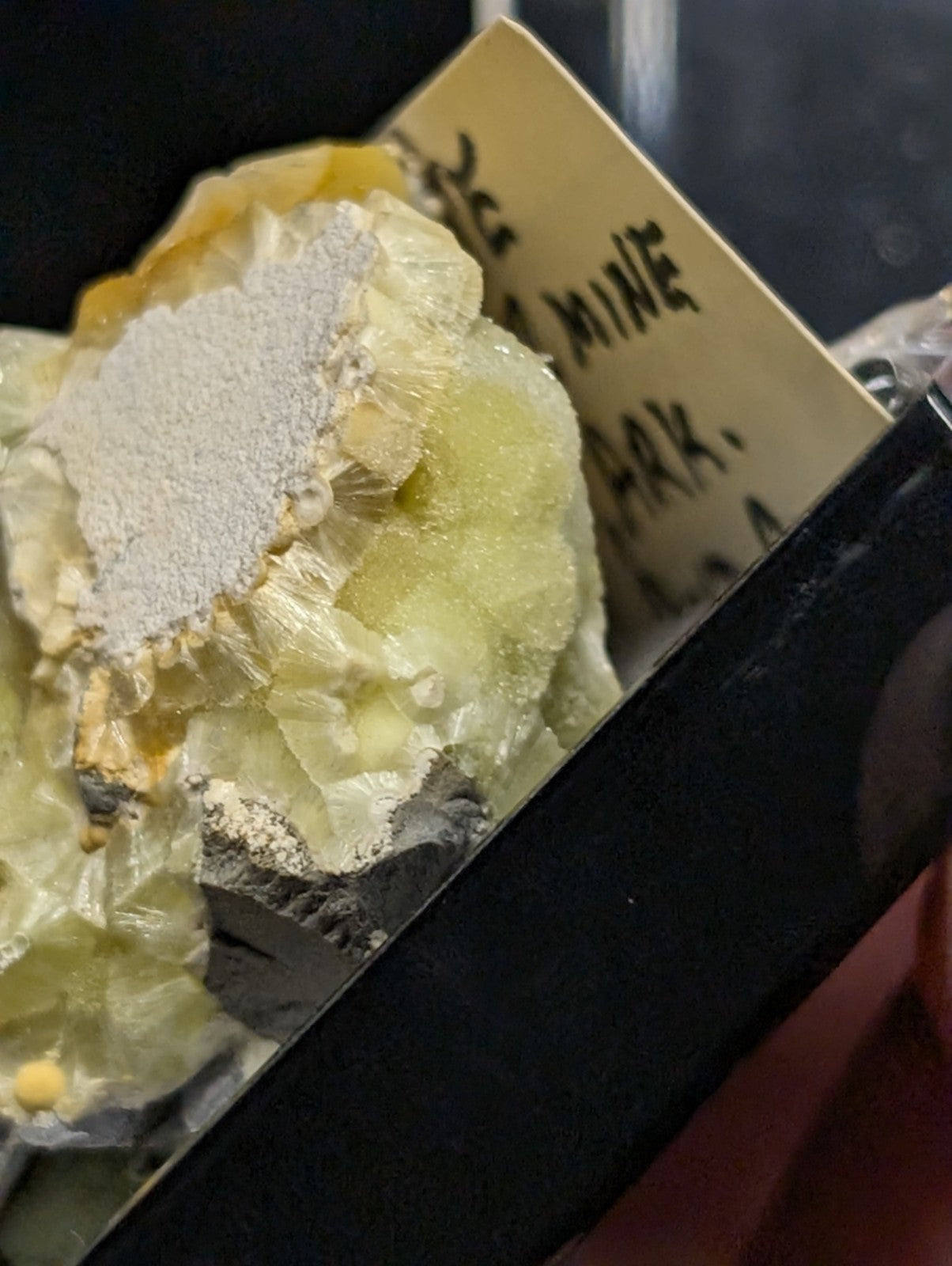 A pale yellow and white mineral specimen with a crystalline, textured surface.